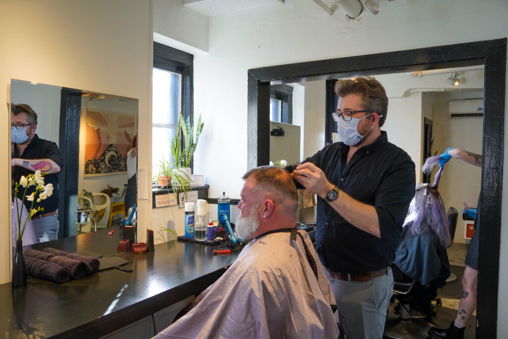 Trent Thomas styles a client's hair.