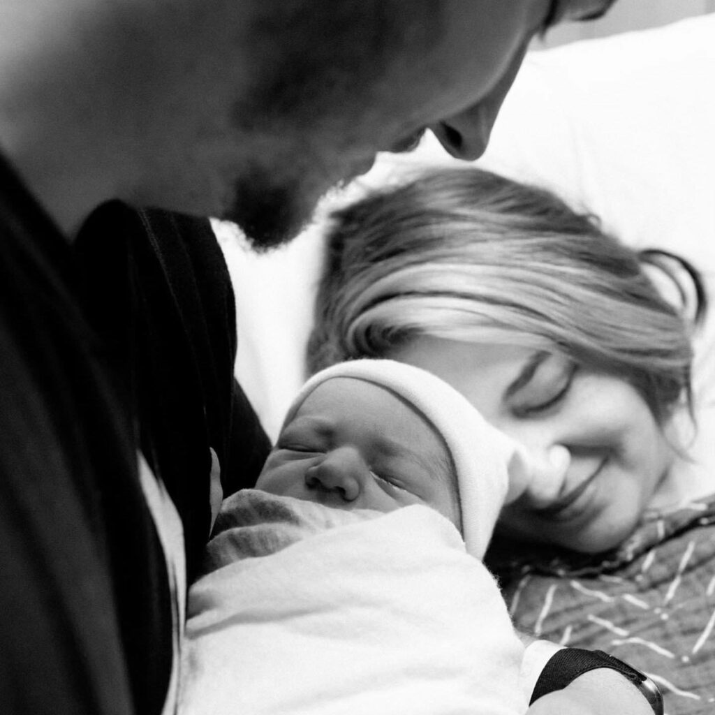 A husband and wife with their newborn child.