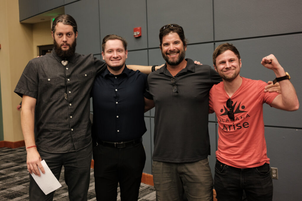 Four people stand for a posed photo. 