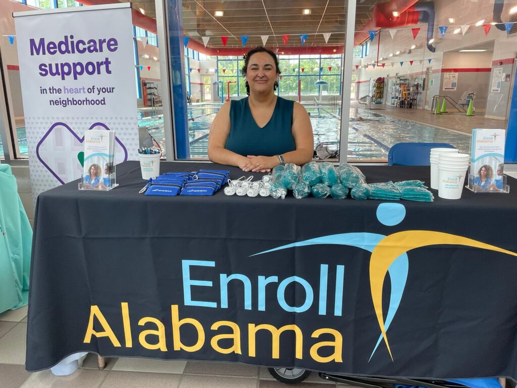 A woman sits at a booth at an event. 