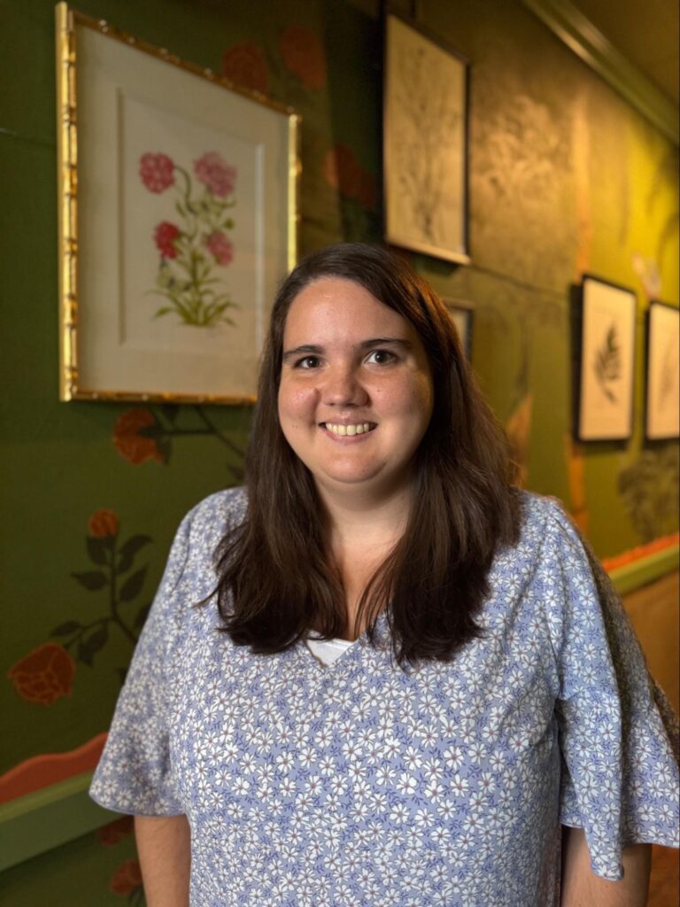 A woman standing and smiling. 