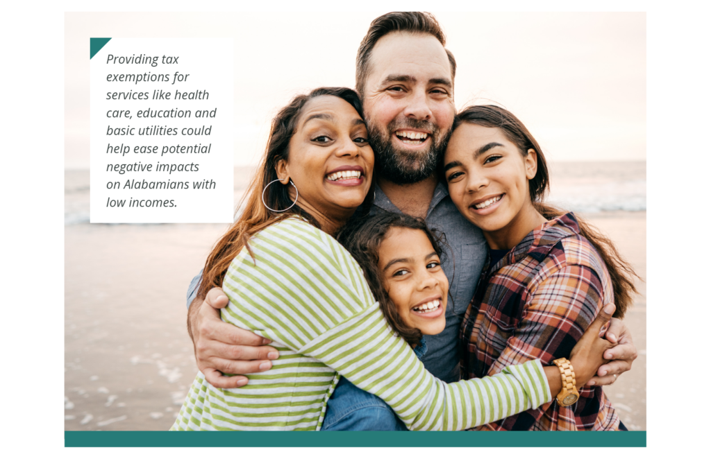 A smiling family of a mother, father and two daughters hug each other while posing for a photo. Caption: Providing tax exemptions for services like health care, education and basic utilities could help ease potential negative impacts on Alabamians with low incomes.